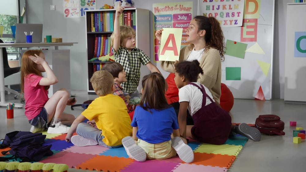 Teacher with small children in a nursery setting, representing the expansion of free childcare funding in September 2025