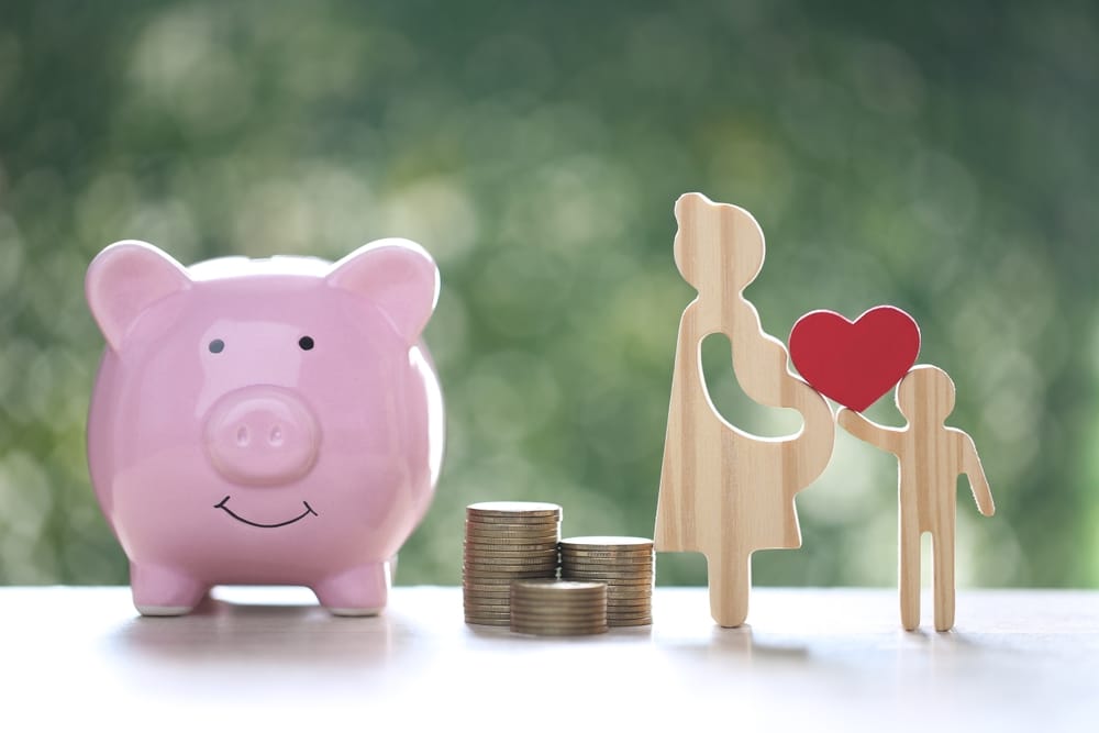 Piggy bank with cartoon couple planning finances together before tax year end, representing financial advice and tax planning in Swindon and Cirencester.